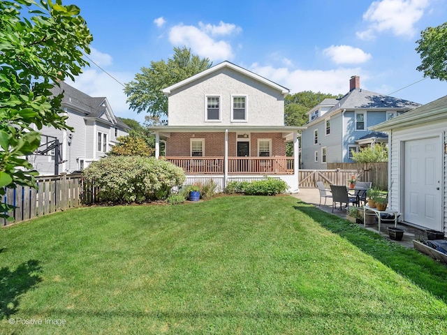 rear view of house with a lawn and a patio area