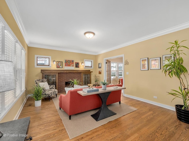 living room with light hardwood / wood-style flooring, crown molding, and a fireplace