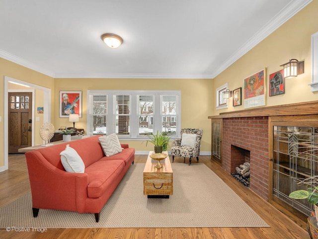 living room featuring a fireplace, ornamental molding, and light hardwood / wood-style flooring