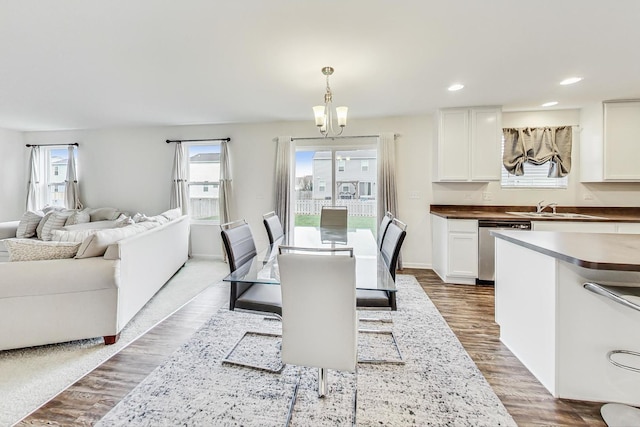 dining space featuring plenty of natural light, light wood-type flooring, sink, and a chandelier