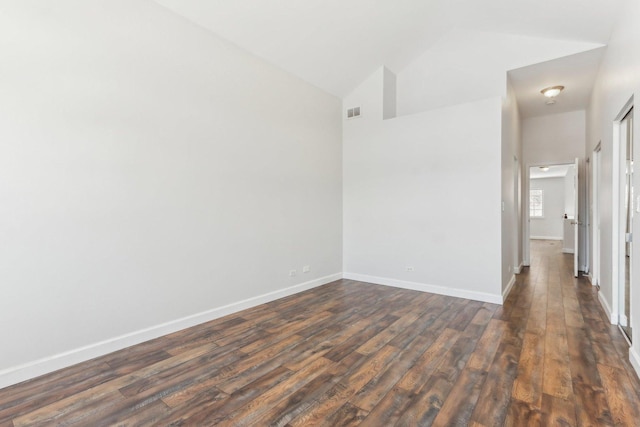 spare room with lofted ceiling and dark wood-type flooring