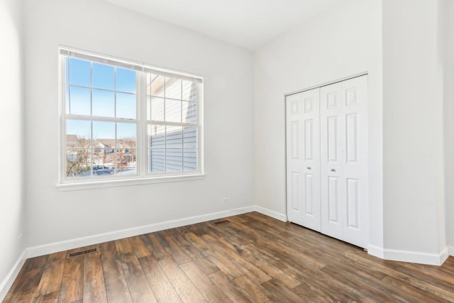 unfurnished bedroom featuring a closet and dark hardwood / wood-style floors