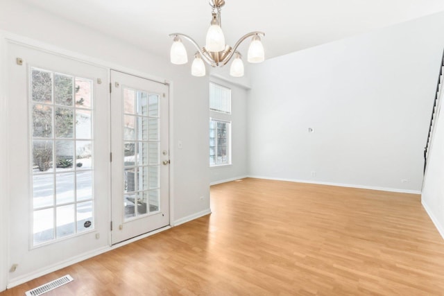 unfurnished dining area featuring a chandelier and light hardwood / wood-style floors