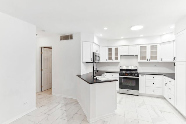 kitchen featuring appliances with stainless steel finishes, white cabinetry, kitchen peninsula, and sink