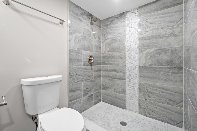 bathroom with tiled shower and toilet