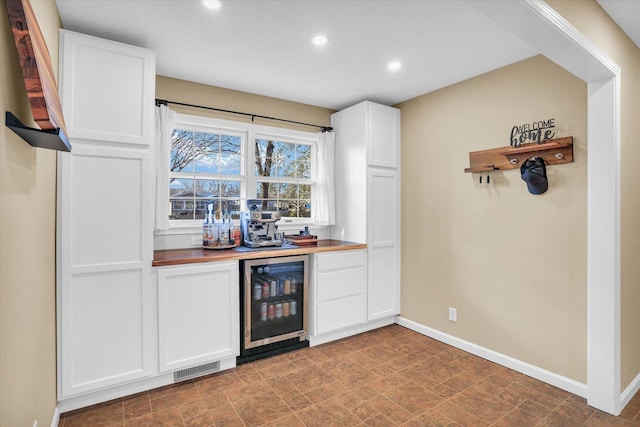 bar featuring white cabinetry, butcher block counters, and wine cooler