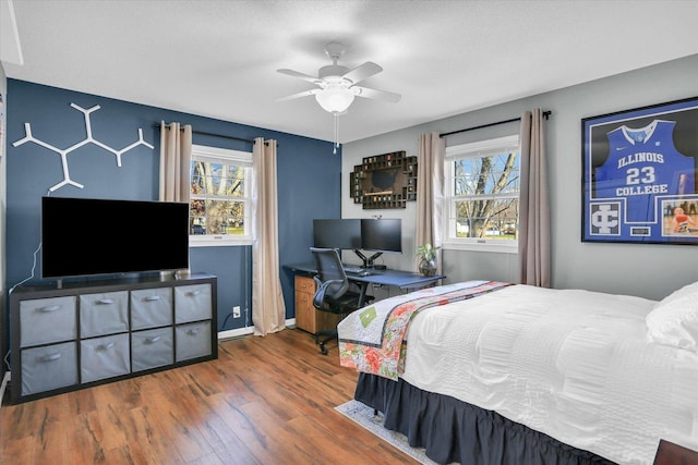 bedroom featuring multiple windows, a textured ceiling, dark hardwood / wood-style floors, and ceiling fan