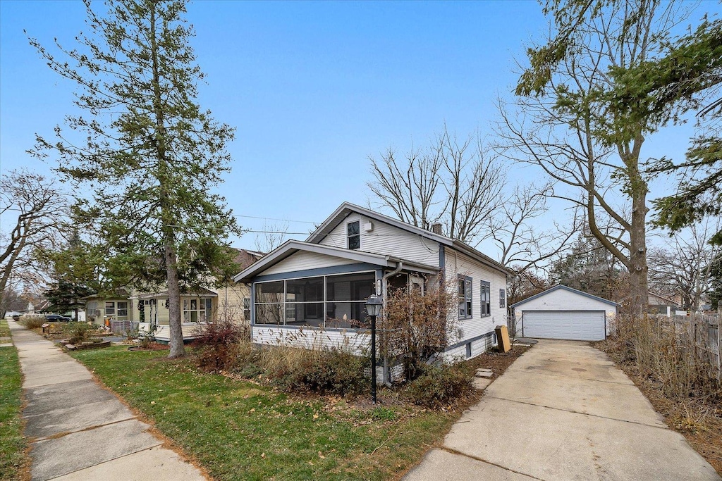 bungalow with a sunroom, an outbuilding, and a garage