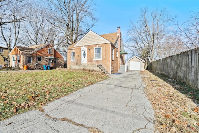 view of front facade with a front yard, a garage, and an outdoor structure