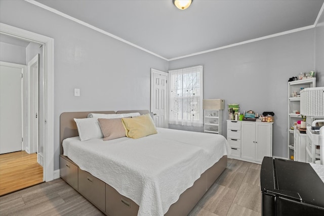 bedroom with light hardwood / wood-style floors and crown molding