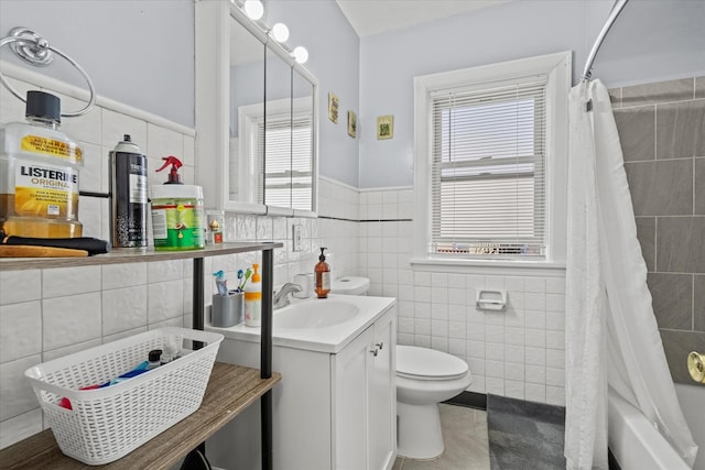 full bathroom with toilet, tile walls, and shower / tub combo with curtain