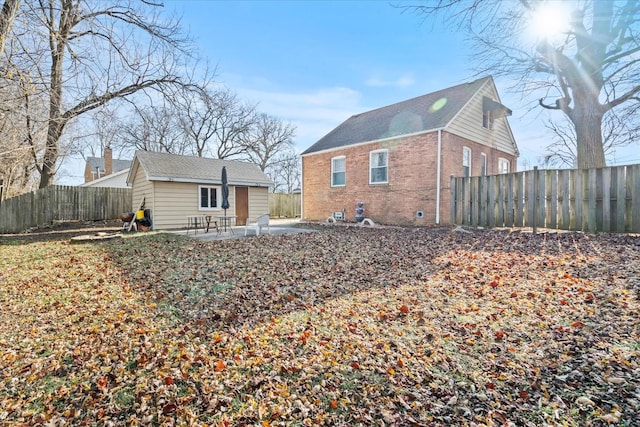 rear view of house with an outbuilding and a patio