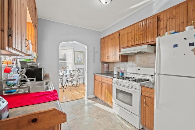 kitchen featuring tasteful backsplash, sink, light tile patterned floors, and white appliances