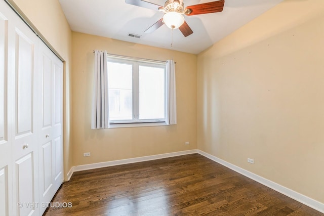 unfurnished bedroom with dark hardwood / wood-style flooring, a closet, and ceiling fan