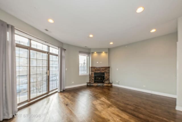 unfurnished living room featuring a fireplace and dark hardwood / wood-style flooring