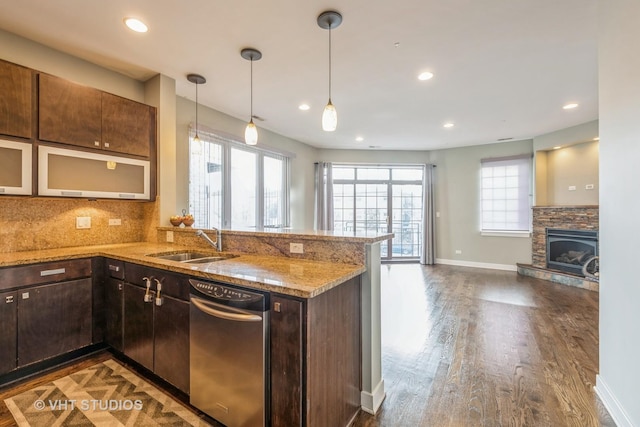 kitchen featuring light stone countertops, sink, tasteful backsplash, dark hardwood / wood-style floors, and kitchen peninsula