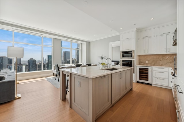 kitchen with sink, beverage cooler, backsplash, gas cooktop, and light stone countertops