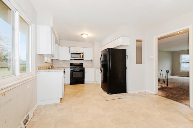 kitchen with sink, light colored carpet, white cabinetry, and black appliances