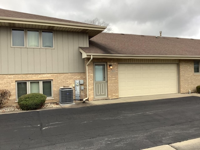 view of front of property featuring a garage and central AC unit