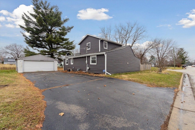 view of front property with a garage, an outdoor structure, and a front yard