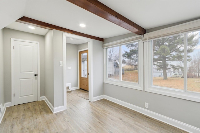 interior space featuring beamed ceiling and light hardwood / wood-style flooring