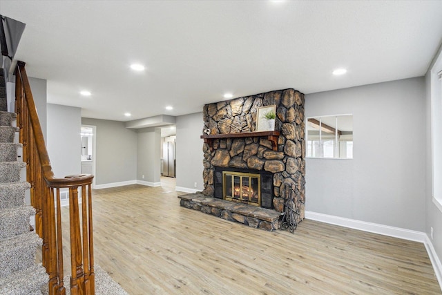 living room with a fireplace and light wood-type flooring