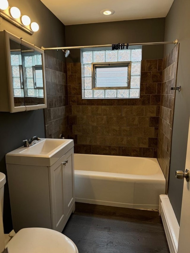 full bathroom with toilet, vanity, and tiled shower / bath