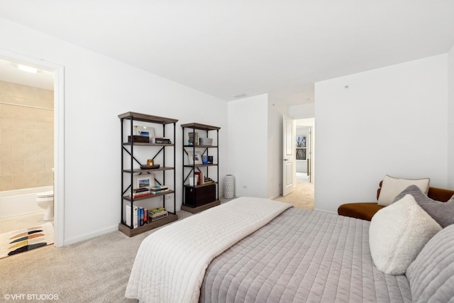 bedroom featuring ensuite bathroom and light colored carpet