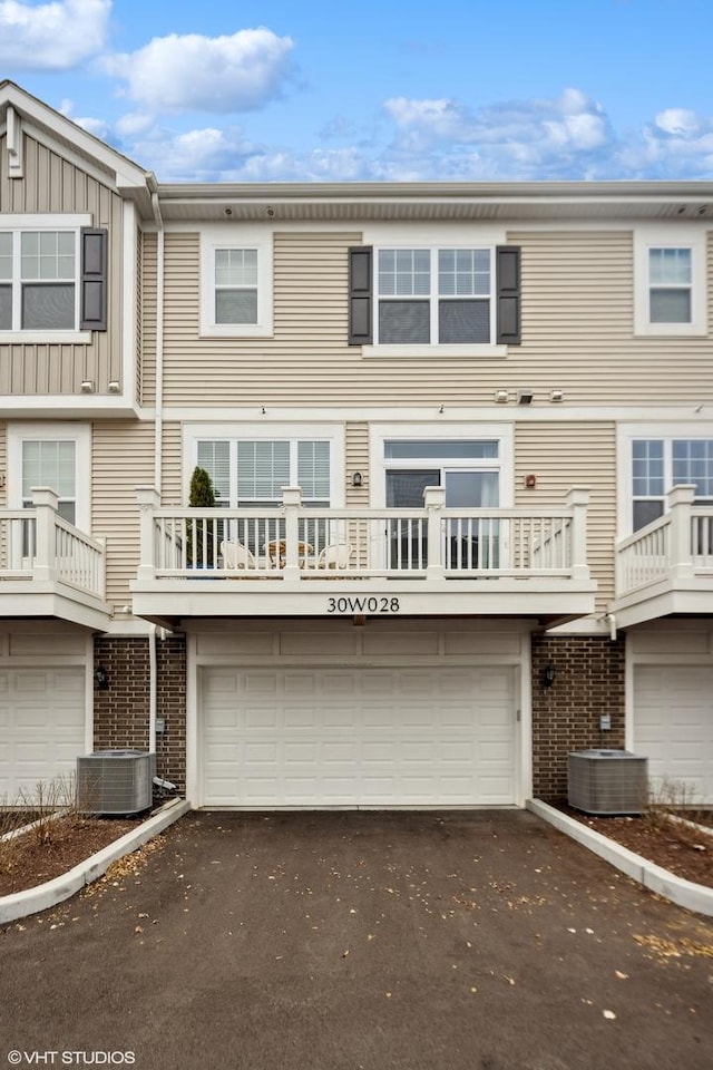 townhome / multi-family property featuring a garage and central AC unit