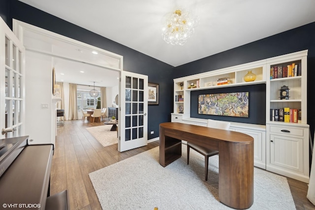 office space featuring light hardwood / wood-style flooring, a chandelier, and french doors