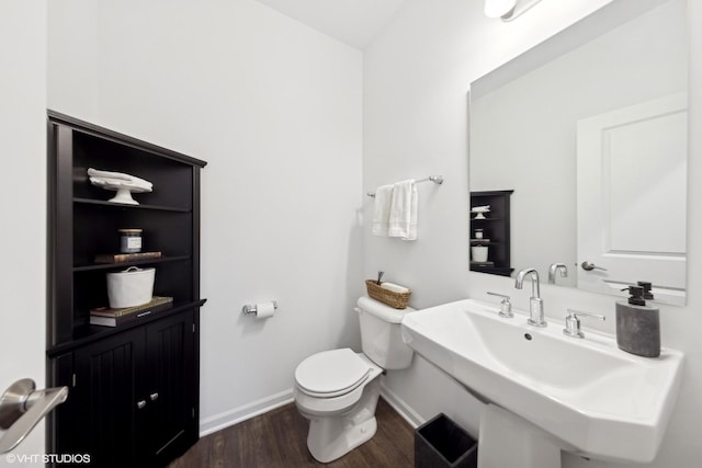 bathroom with hardwood / wood-style flooring, toilet, and sink