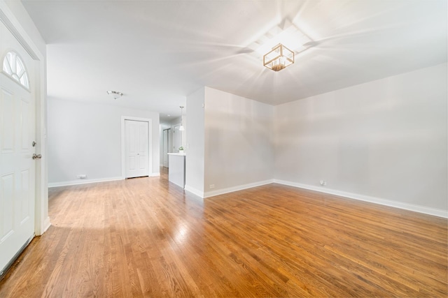 empty room featuring baseboards and light wood finished floors