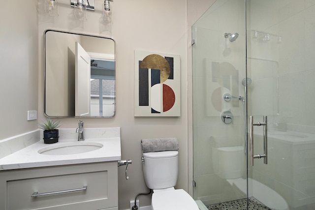 bathroom featuring an enclosed shower, vanity, and toilet