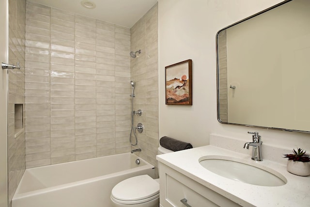 full bathroom featuring vanity, tiled shower / bath combo, and toilet