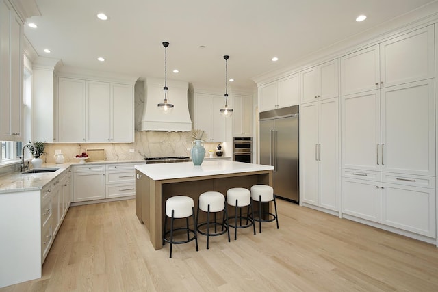 kitchen with custom exhaust hood, a center island, sink, light wood-type flooring, and stainless steel appliances