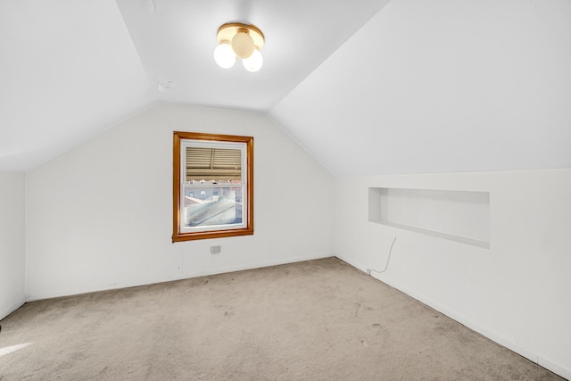 bonus room with light carpet and vaulted ceiling