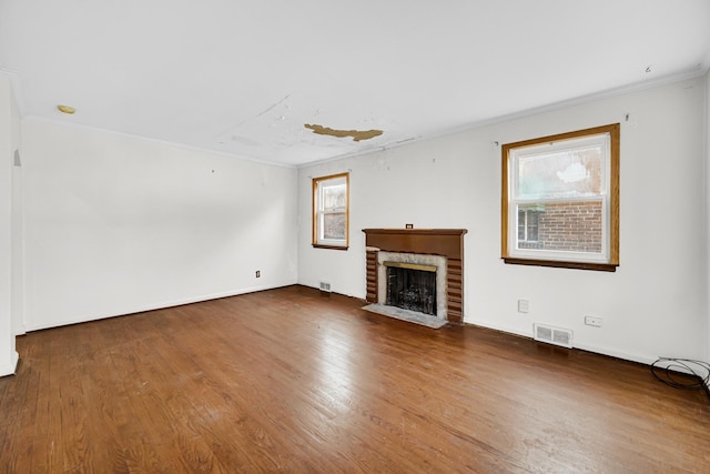 unfurnished living room with dark hardwood / wood-style floors, a brick fireplace, and crown molding