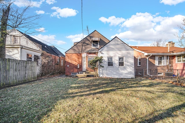 rear view of property with a lawn