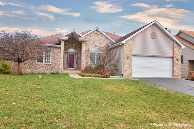 view of front of house featuring a yard and a garage