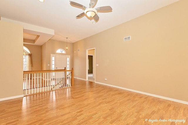 empty room with ceiling fan and light hardwood / wood-style flooring