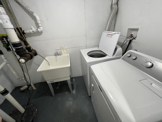 clothes washing area with washer and clothes dryer and sink