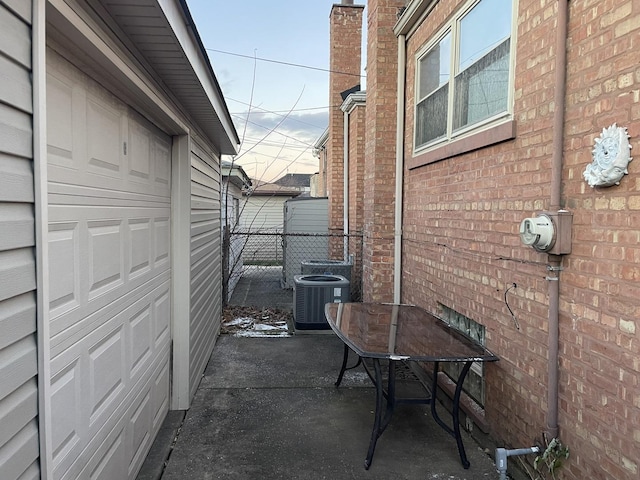 view of patio featuring central AC unit and a garage