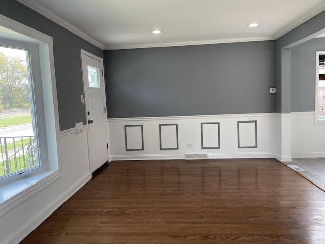 foyer entrance with crown molding, dark wood-type flooring, and a wealth of natural light