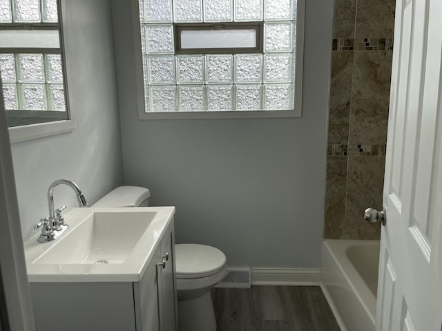 full bathroom featuring vanity, toilet, wood-type flooring, and tiled shower / bath