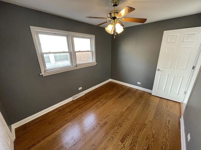 empty room with hardwood / wood-style floors and ceiling fan