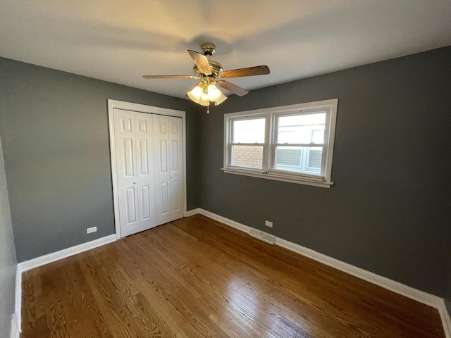 unfurnished bedroom with hardwood / wood-style flooring, ceiling fan, and a closet