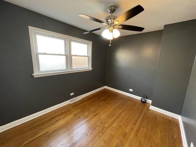 unfurnished room with ceiling fan and hardwood / wood-style flooring