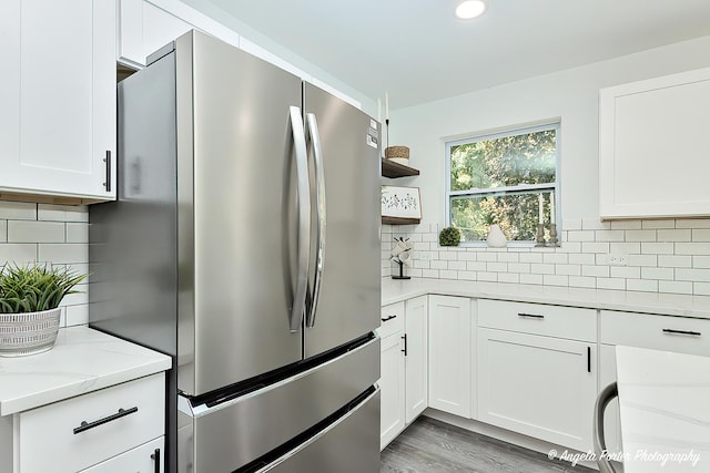 kitchen featuring white cabinets, stainless steel fridge, and tasteful backsplash