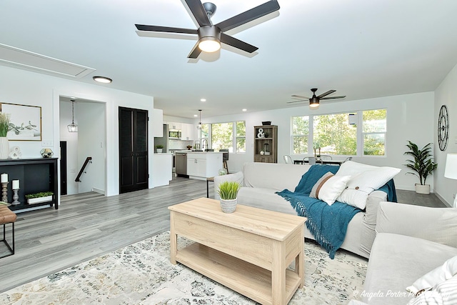 living room with ceiling fan and light hardwood / wood-style floors