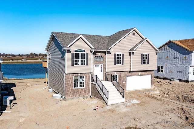 bi-level home featuring a water view and a garage